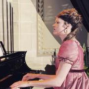 Laura Klein dressed in Regency clothes and playing piano